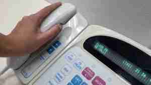 nurse's hand on a phone as part of nurse call system