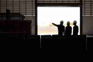 silhouettes of three people assessing a facility