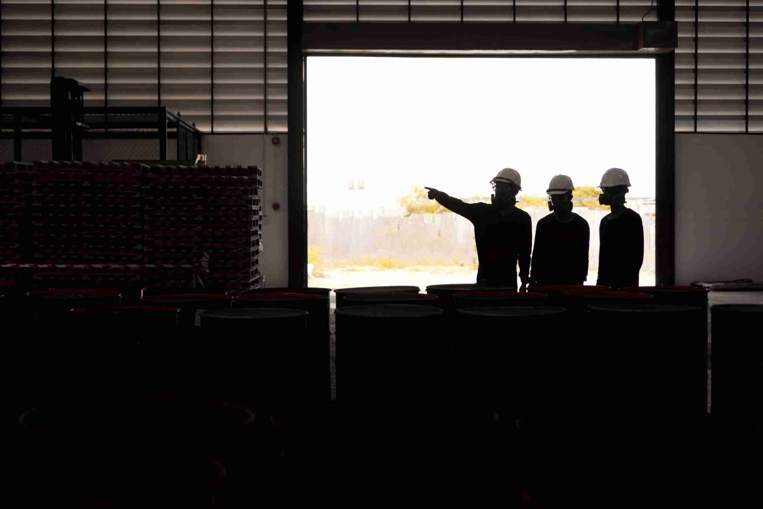 silhouettes of three people assessing a facility