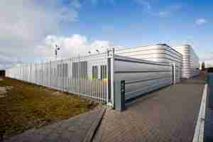 perimeter protection - metal fence and electronic access gate around a building