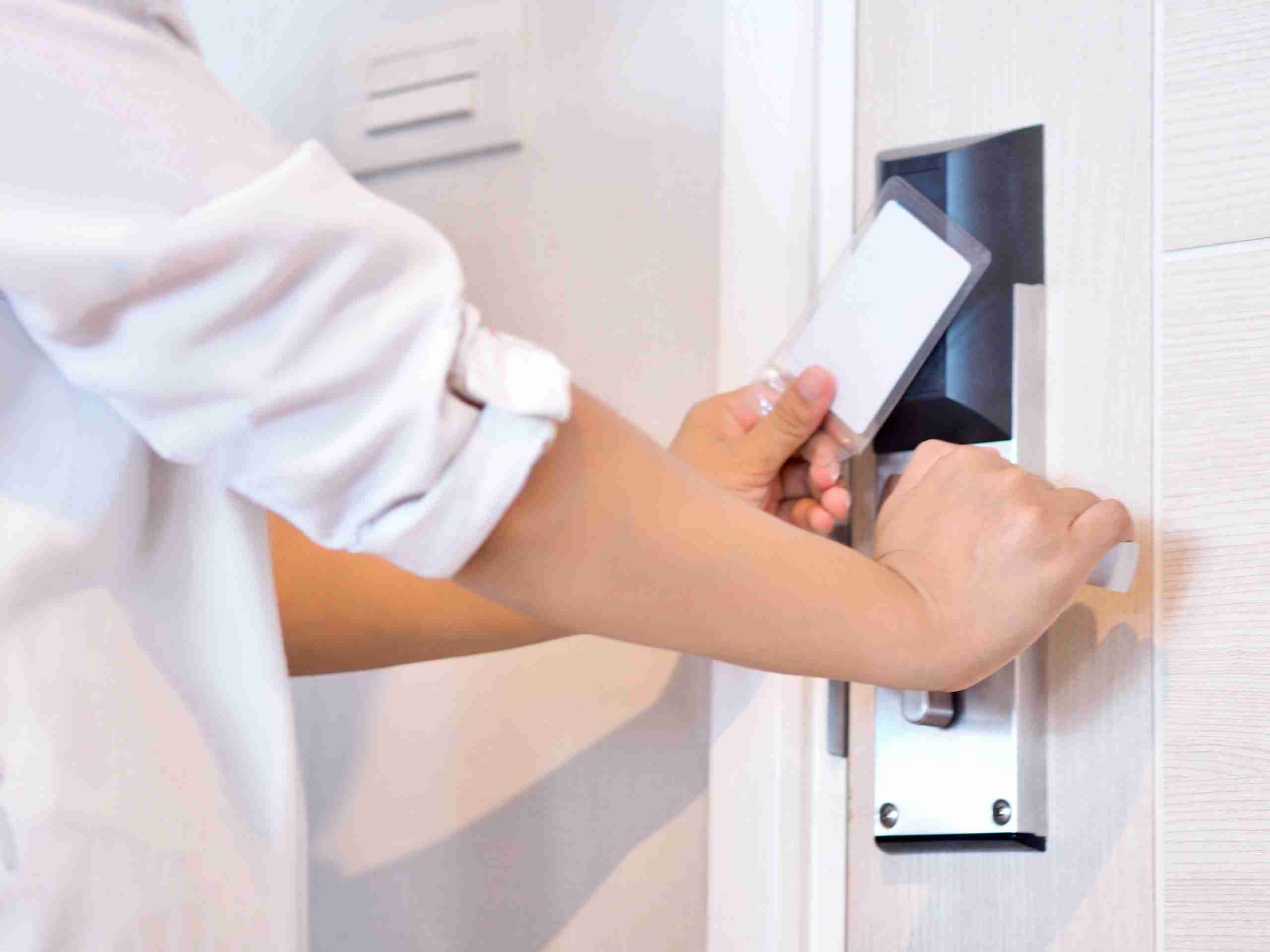 person using a key card to access a secure door