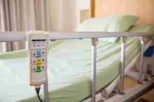 hospital bed with call system remote hanging on bed rail