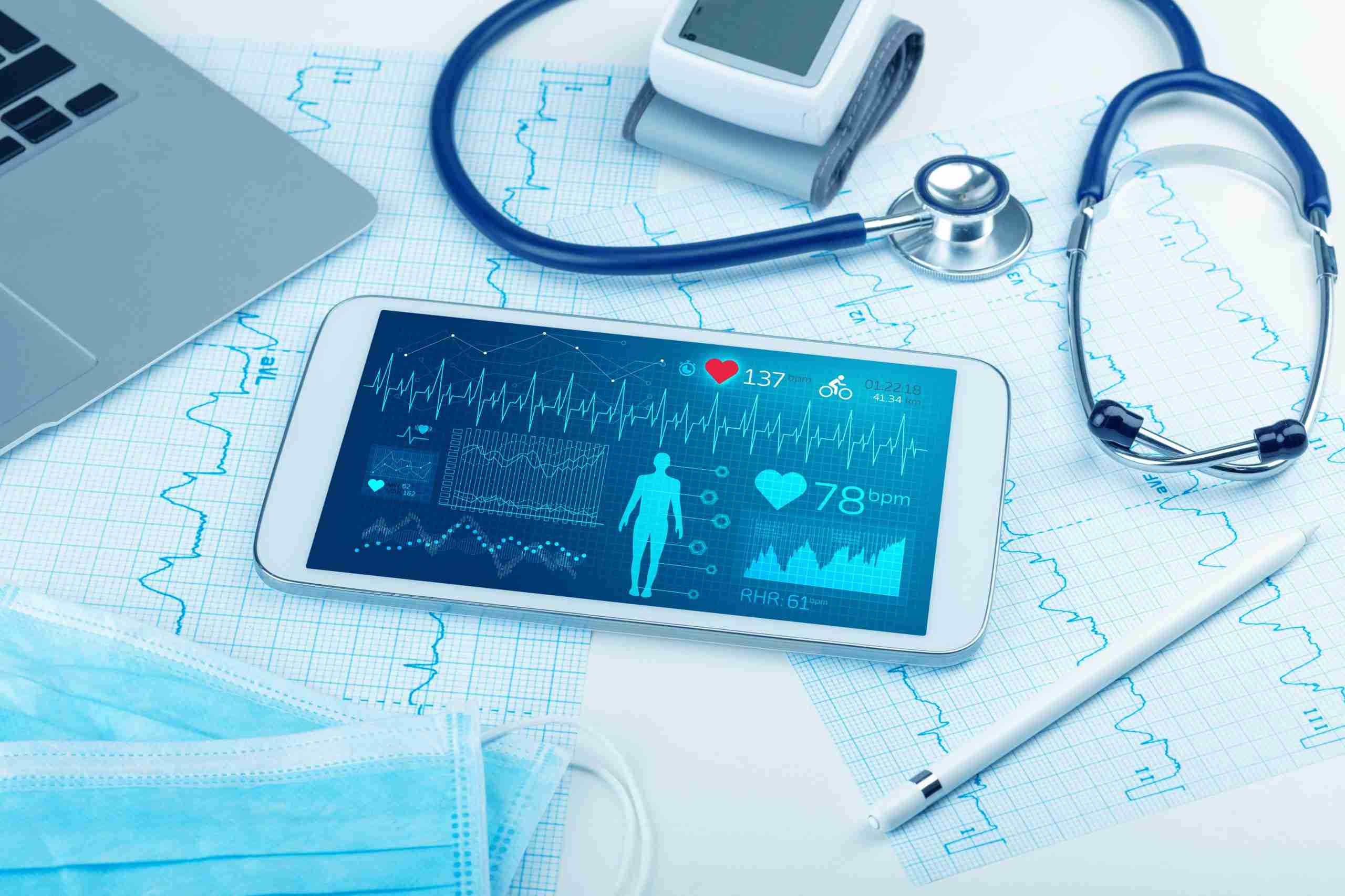 medical technology concept - charts, laptop, stethoscope, and tablet with live medical stats