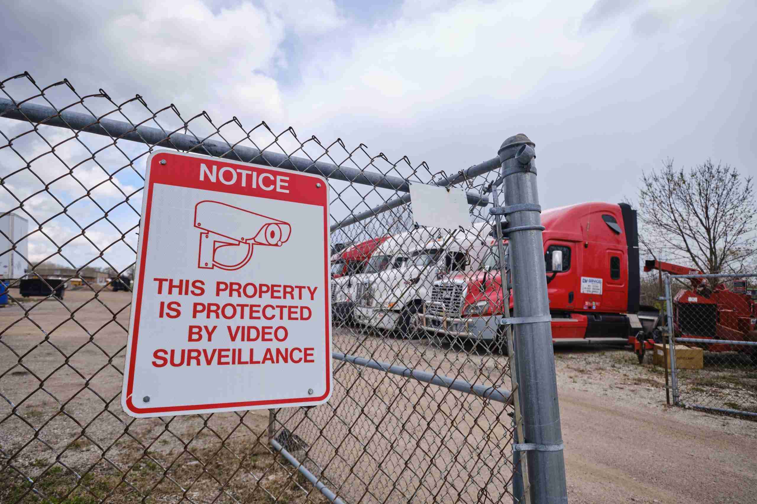 parking lot with video surveillance notice sign on the fence