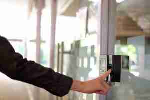 biometric access - person using a fingerprint scanner on a door